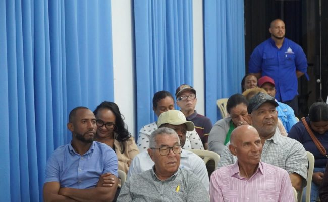 Personas reunidas en salón durante reunión comunitaria