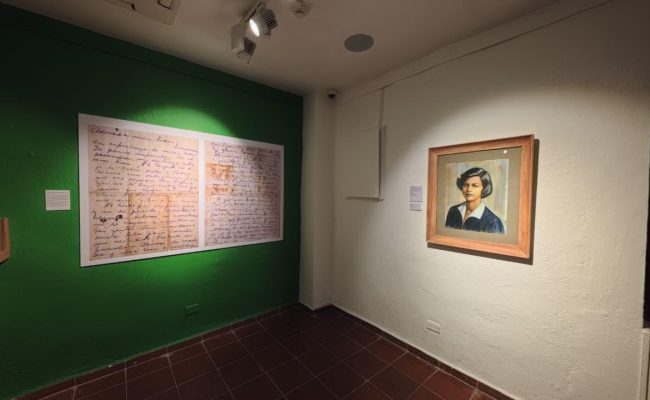 Sala de museo con retrato y cartas antiguas
