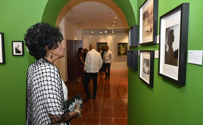 Mujer observa fotografías en galería de arte