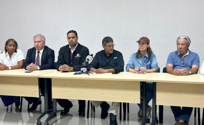Funcionarios en rueda de prensa sentados en mesa