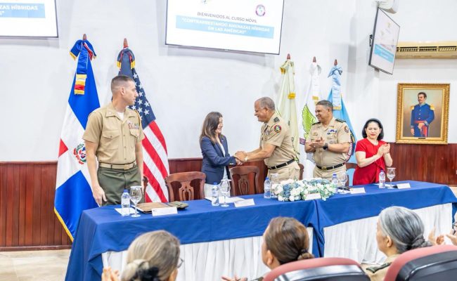 Acto oficial militar con saludo protocolar y banderas
