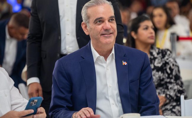 Hombre con traje y pin dominicano en evento