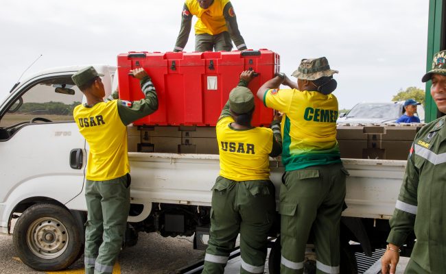 Equipo de rescate carga caja roja en camioneta