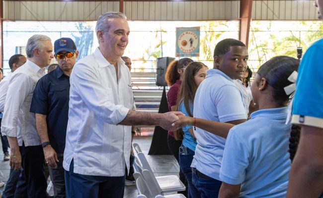 Funcionario saluda estudiantes en actividad escolar