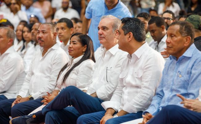 Autoridades sentadas en acto público multitudinario