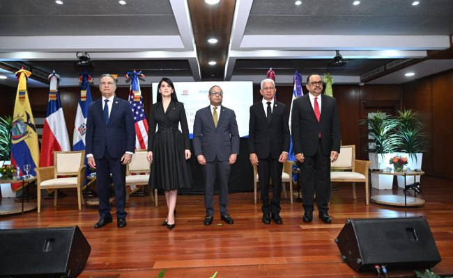Autoridades en acto oficial con banderas internacionales