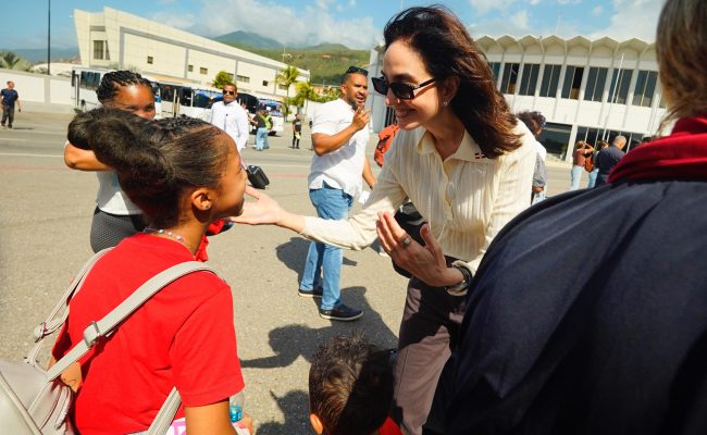 Mujer saluda cariñosamente a niña en aeropuerto