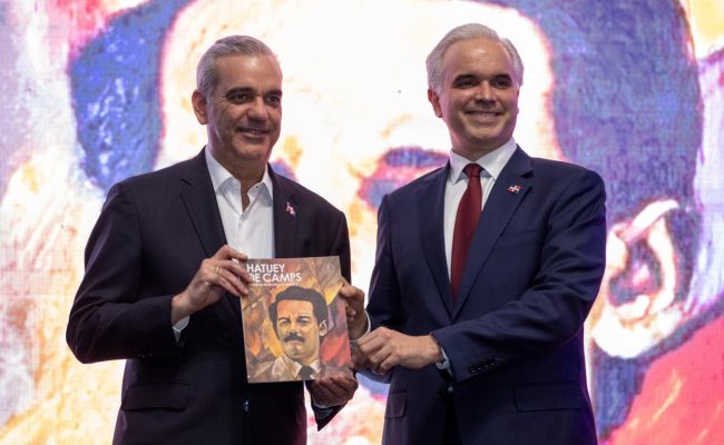 Dos hombres sostienen libro Hatuey de Camps