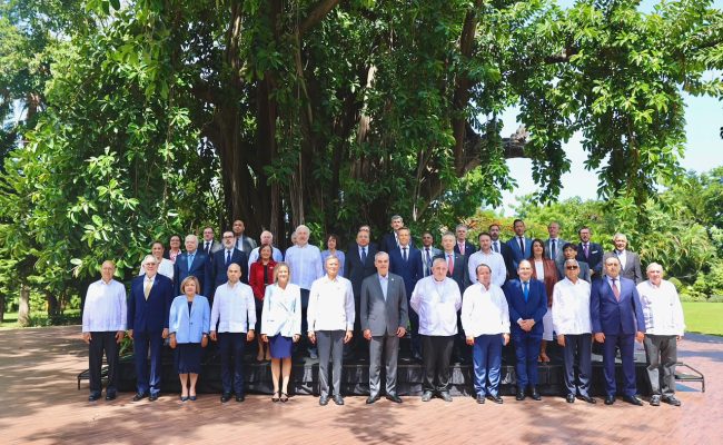 Grupo de autoridades posando bajo árbol frondoso