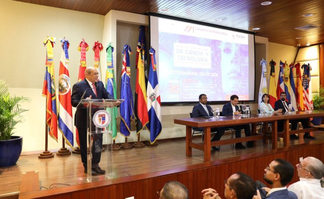 Orador en congreso internacional con banderas detrás