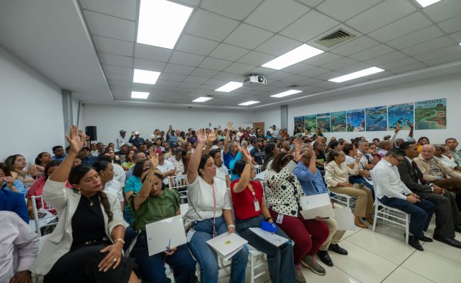 Personas levantan la mano en reunión comunitaria