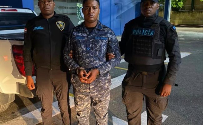 Agentes policiales detienen hombre frente a edificio azul
