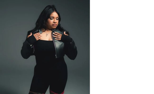 Mujer posando con chaqueta negra y botas camuflaje