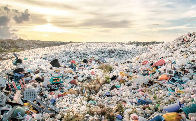 Gran vertedero lleno de desechos plásticos al atardecer