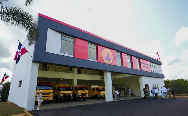 Edificio militar con camiones amarillos y bandera dominicana