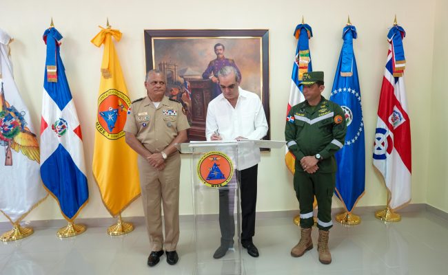 Funcionario firma documento junto a militares dominicanos