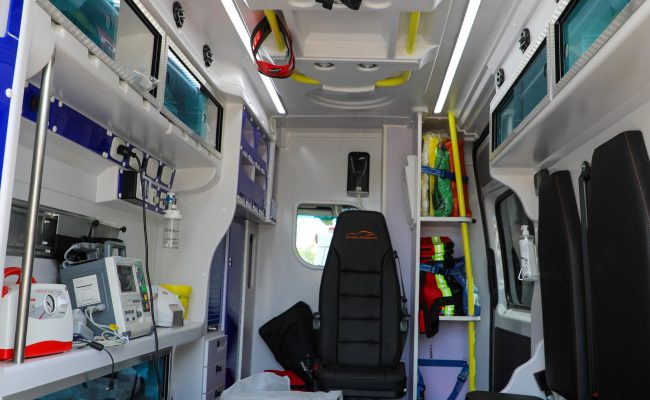 Interior de ambulancia equipada con camilla y equipos médicos