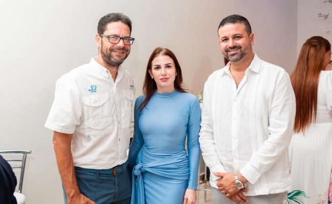 Tres personas posan en evento social elegante