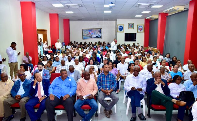 Salón lleno de personas en reunión comunitaria