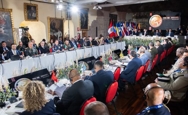 Cumbre militar internacional con delegados y banderas